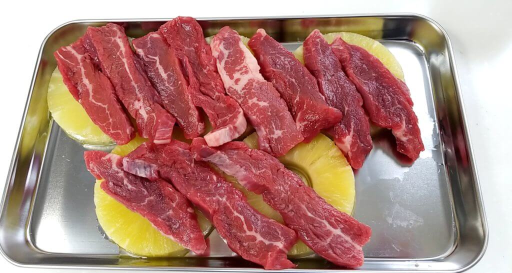 輪切りにしたパイナップルの上に肉を敷き詰める